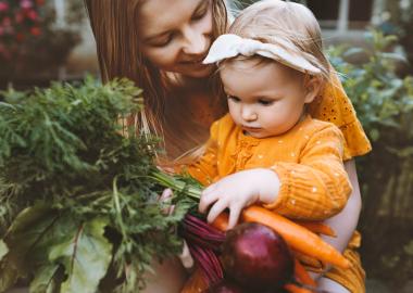 Mom and baby holding vegetables